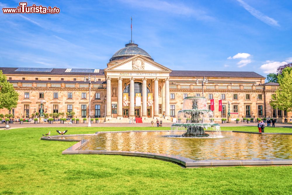 Immagine La facciata d'ingresso del Casinò di Wiesbaden con i suoi giardini e la fontana in una giornata di sole, Germania.