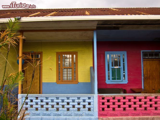 Immagine Facciate colorate con palme a San José, Costa Rica. Abitazioni decorate nelle tonalità del rosso e del giallo in questo angolo della capitale - © QArts / Shutterstock.com