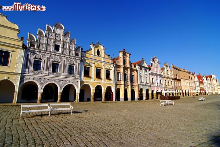 Immagine Le facciate variopinte degli edifici affacciati sulla piazza principale di Telc, Repubblica Ceca. Le abitazioni sono abbellite da un porticato che poggia su colonne con intarsi e decori ornamentali.