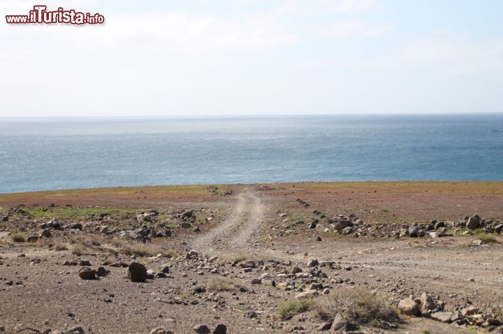 Immagine Percorso che porta a Faro de punta Jandia, Fuerteventura (Isole Canarie) - Nel cuore del sud portoghese, qui nella parte più meridionale dell'isola, trionfa un paesaggio particolare, fatto dai contrasti estremi del mare limpido e dal panorama naturale dei dintorni, rimasto rurale e per questo degno di moltissimo fascino. Particolari le stradine su terra, come si vede dall'immagine.