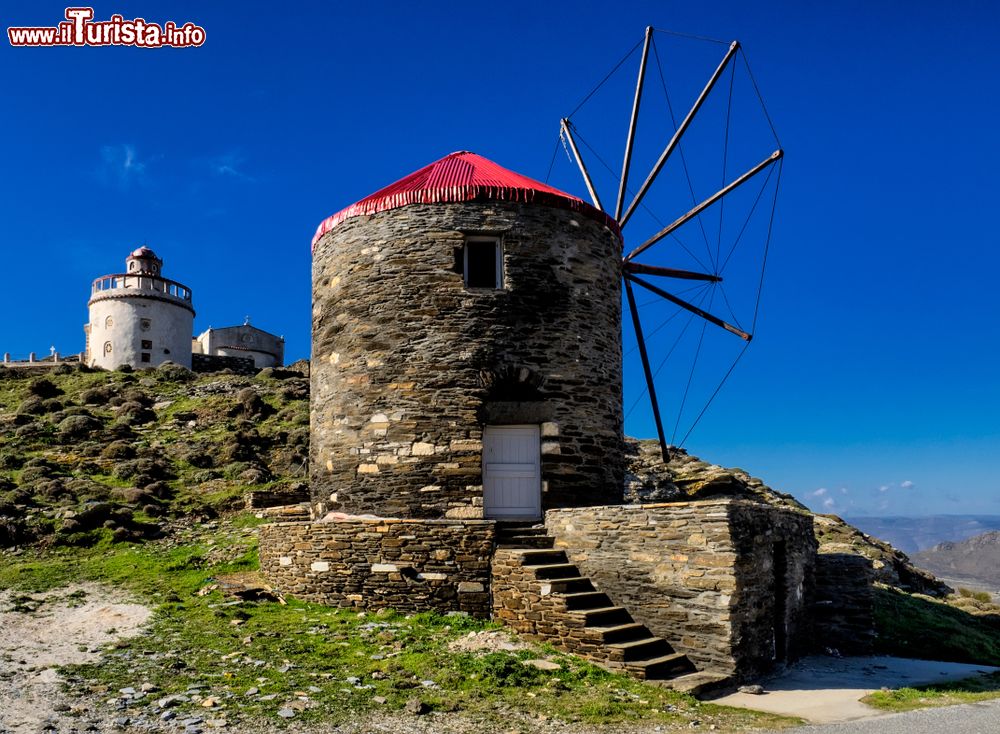 Immagine Faro e mulino a vento sull'isola di Tino, Cicladi, Grecia. Questa graziosa isola è caratterizzata da retaggi veneziani, buona cucina e mare cristallino.