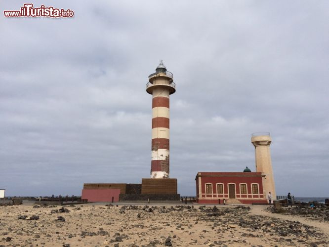 Immagine Il faro El Toston a El Cotillo, Fuerteventura, Spagna - Si trova a 5 km circa dalla località di El Cotillo, a Punta Ballena. Il faro El Toston fu costruito nel 1891 ma solo nel 1987 è diventato operativo a tutti gli effetti. La sua luce bianca in realtà nasconde un trittico di indicazioni: insieme al colosso dell'Isola di Lobos (il faro martino) e a quello a Lanzarote (il faro pechiguera), costituisce un aiuto fondamentale di segnalazione per le imbarcazioni che passano dallo Stretto di Bocaina.