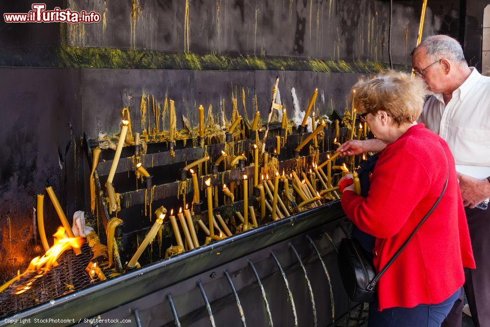 Immagine Fedeli accendono candele votive al santuario di Sao Bento da Porta Aberta, Terras de Bouro, Portogallo  - © StockPhotosArt / Shutterstock.com