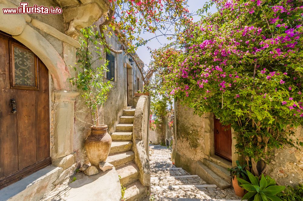 Immagine Fiori decorano una viuzza soleggiata nella città vecchia di Adrano, Sicilia, in estate.