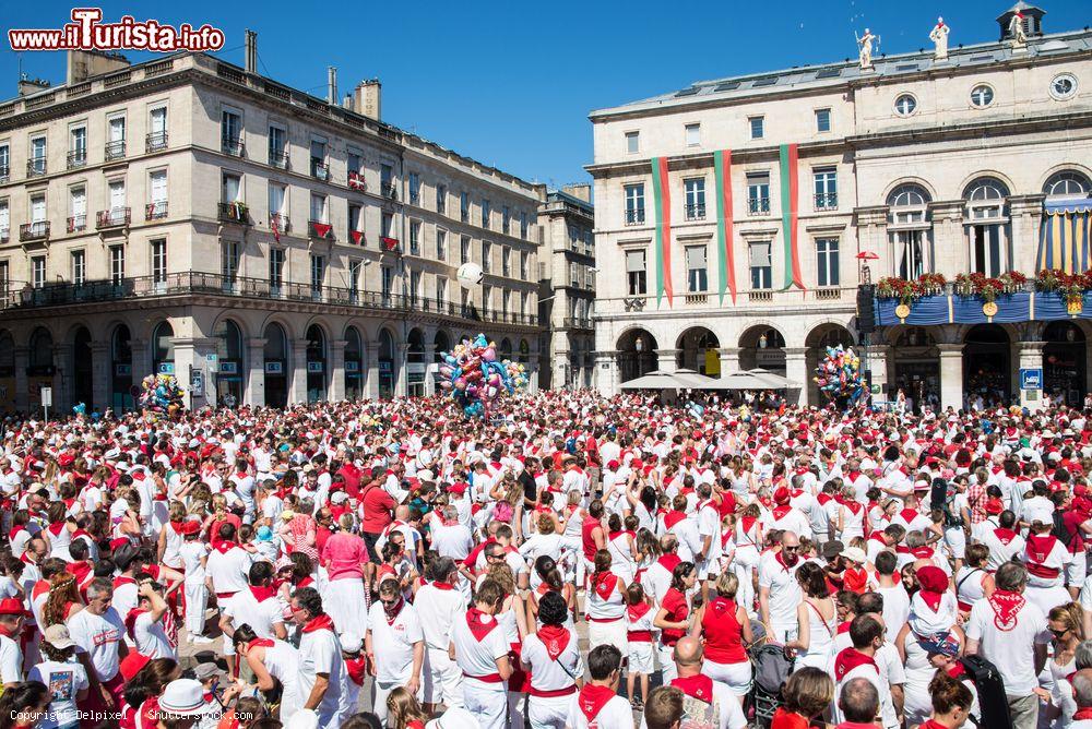 Immagine Una folla di persone vestite di bianco e rosso al Summer Festival di Bayonne, Francia - © Delpixel / Shutterstock.com