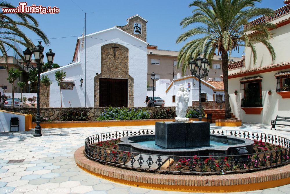 Immagine Una fontana con scultura nel centro di Estepona (Spagna) con una graziosa chiesa in calce e pietra sullo sfondo - © Caron Badkin / Shutterstock.com