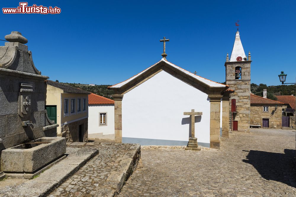 Immagine Fontana in pietra e case storiche nel villaggio di Castelo Mendo, Portogallo.