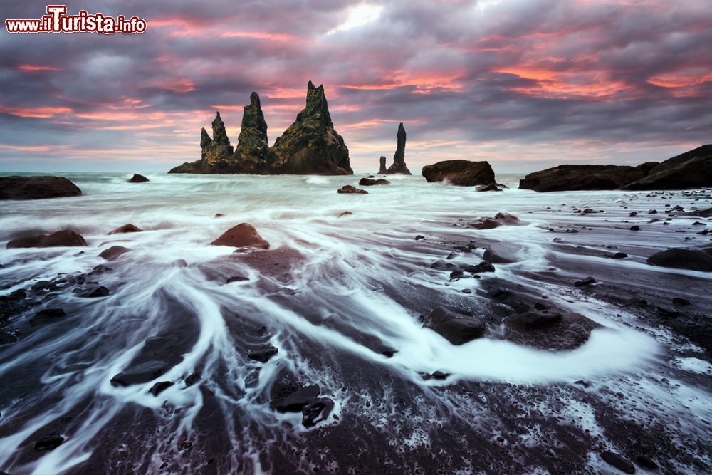 Immagine Formazioni di basalto di fronte alla spiaggia nera di Reynisdrangar, Vik i Myrdal, Islanda. A fare da cornice, uno splendido cielo con i colori del tramonto.