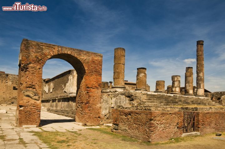 Immagine Foro di Pompei, Campania - Punto centrale della città romana, il Foro era una grande piazza circondata da archi su cui si stagliavano le statue degli dei e dei benefattori oggi, purtroppo, non più visibili in quanto andate perdute. Rappresentava il cuore economico, politico e religioso di Pompei dove si svolgevano manifestazioni, contrattazioni e dibattiti. La pavimentazione originaria era in tufo, poi sostituito da lastre di travertino, e completamente vietata ai carri © ivan bastien / Shutterstock.com