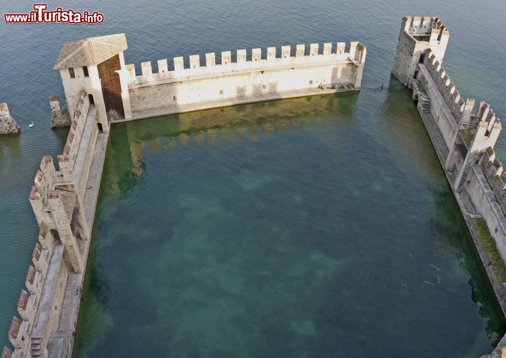 Immagine Fortificazione medievale del porto di Sirmione, provincia di Brescia, Lombardia. Utilizzato dalla flotta navale scaligera, questo rappresenta l'unico punto di accesso allo storico centro di Sirmione.