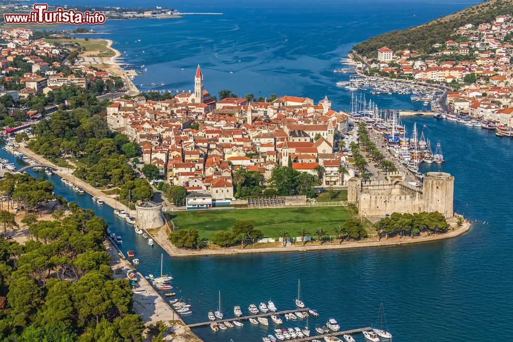 Immagine Foto aerea della città vecchia di Trogir, Croazia, con il castello di Kamerlengo. Il centro storico è racchiuso in una piccola isola protetta da una cinta muraria colelgata da due ponti alla terraferma e a un'altra isola a sud.