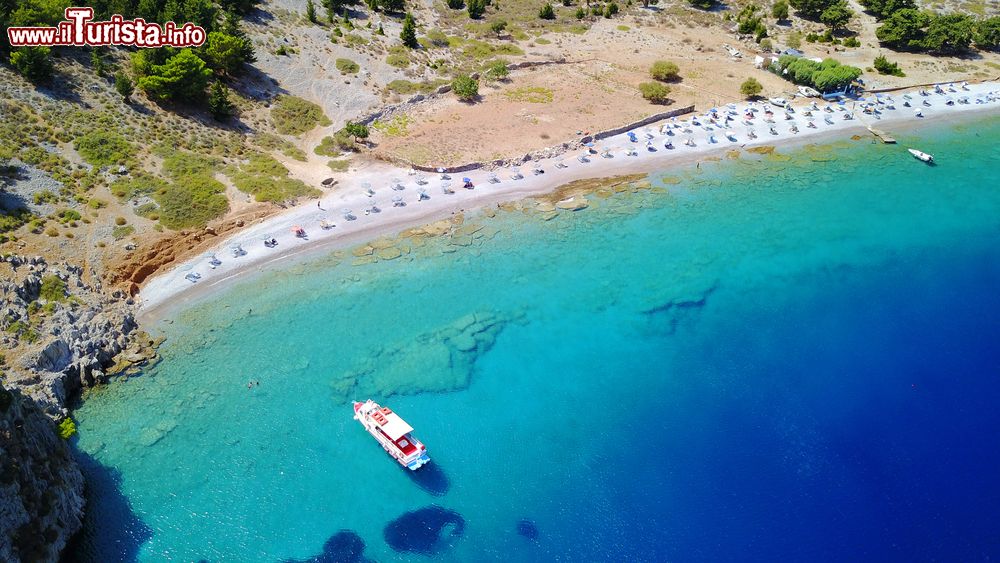 Immagine Foto dal drone della spiaggia rocciosa di Nannou sull'isola di Symi, Grecia. Con i suoi ciottoli è una delle più selvagge e famose dell'isola greca.