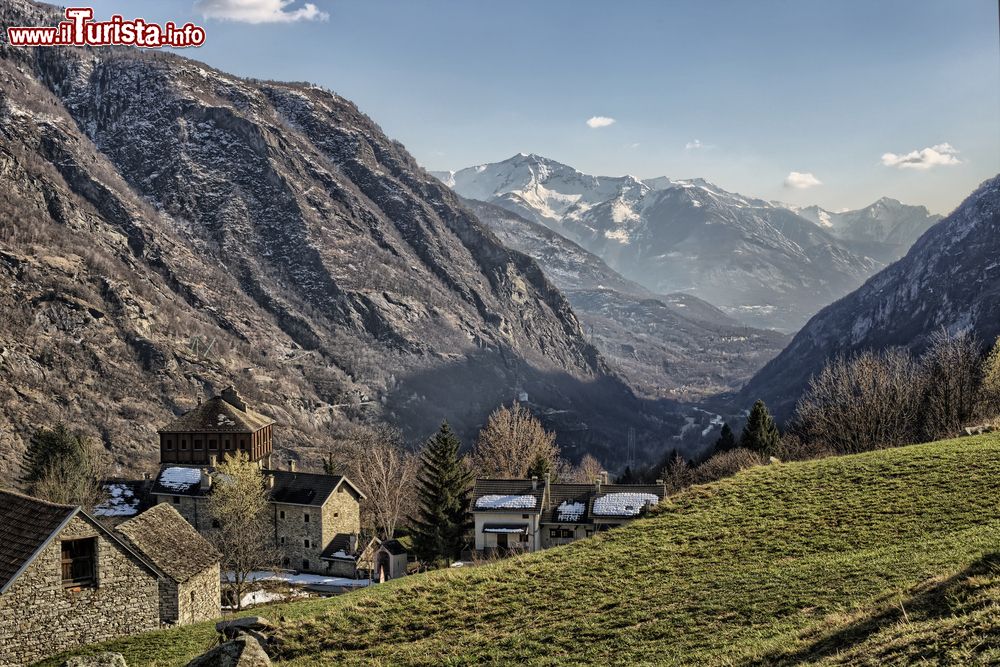 Immagine Fotografia della vallata di Crodo, Piemonte, Italia. A rendere ancora più suggestivo questo scenario è la spolverata di soffice neve che imbianca le montagne sullo sfondo oltre che i tetti delle abitazioni in pietra.