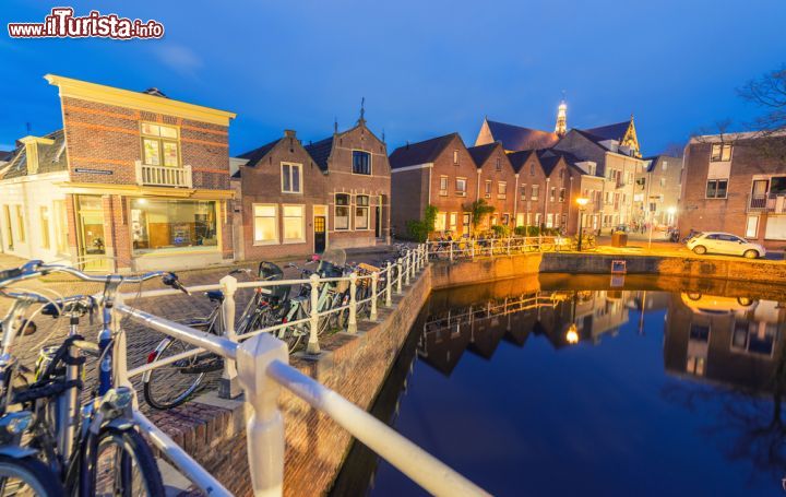 Immagine Fotografia notturna di Alkmaar - Se di giorno una distesa d'acqua e delle biciclette, binomio piuttosto diffuso in Olanda, scappa un sorriso per la bellezza dell'immagine, figuriamoci di notte, quando ogni aspetto di Alkmaar diventa soffuso e magico. Le luci calde, molto intense che sono presenti nelle case e nelle strade, regalano un calore unico a certi scorci, anche quelli diurni - © pisaphotography / Shutterstock.com