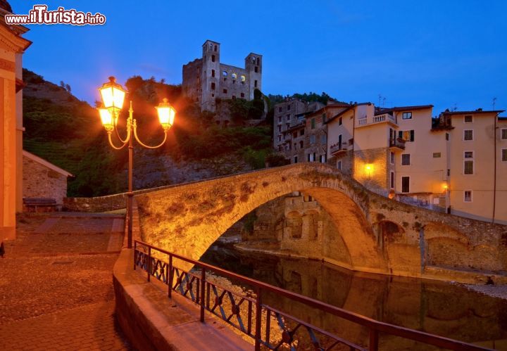 Immagine Dolceacqua di notte, Liguria, Italia - Con le luci del tramonto questo grazioso villaggio medievale della Val Nervia, lungo l'omonimo torrente, regala a chi lo visita un'atmosfera ancora più suggestiva © LianeM / Shutterstock.com