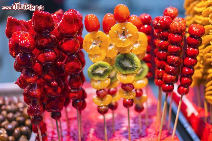 Immagine Frutta assortita in stecchi in una bancarella di Nanjing, Cina. Sono tradizionai snack cinesi - © aphotostory / Shutterstock.com