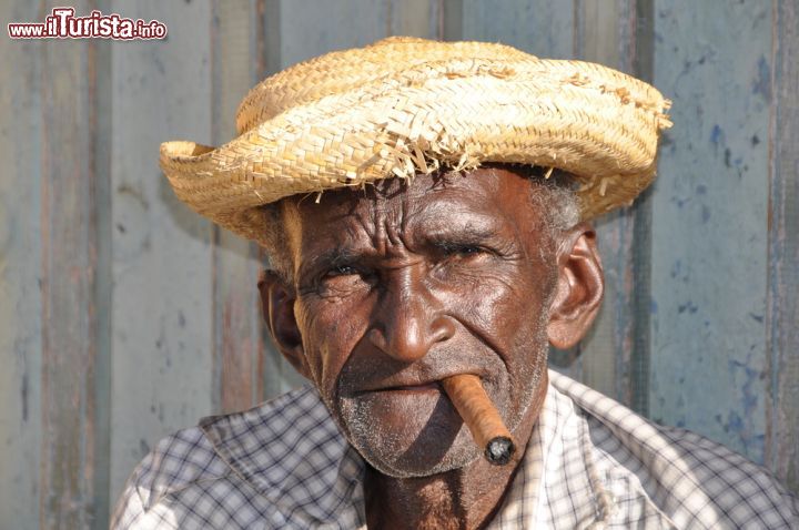 Immagine Un fumatore di sigari a Trinidad, Cuba - L'isola di Cuba e i sigari hanno una lunga storia e una tradizione ben salda che ebbero inizio nella città di Santa Clara e che hanno portato Cuba, oggi, ad essere senza ombra di dubbio il paese con la migliore produzione di sigari del mondo. - © Styve Reineck / Shutterstock.comr