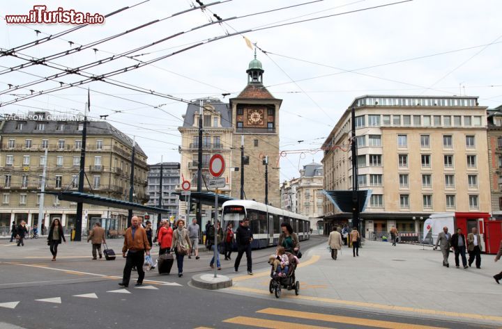 Immagine Gente a passeggio in piazza Bel-Air vicino a l'Ile Clock Tower di Ginevra, Svizzera. La fermata di Bel-Air è uno degli snodi più importanti per il trasporto pubblico cittadino - © InnaFelker / Shutterstock.com