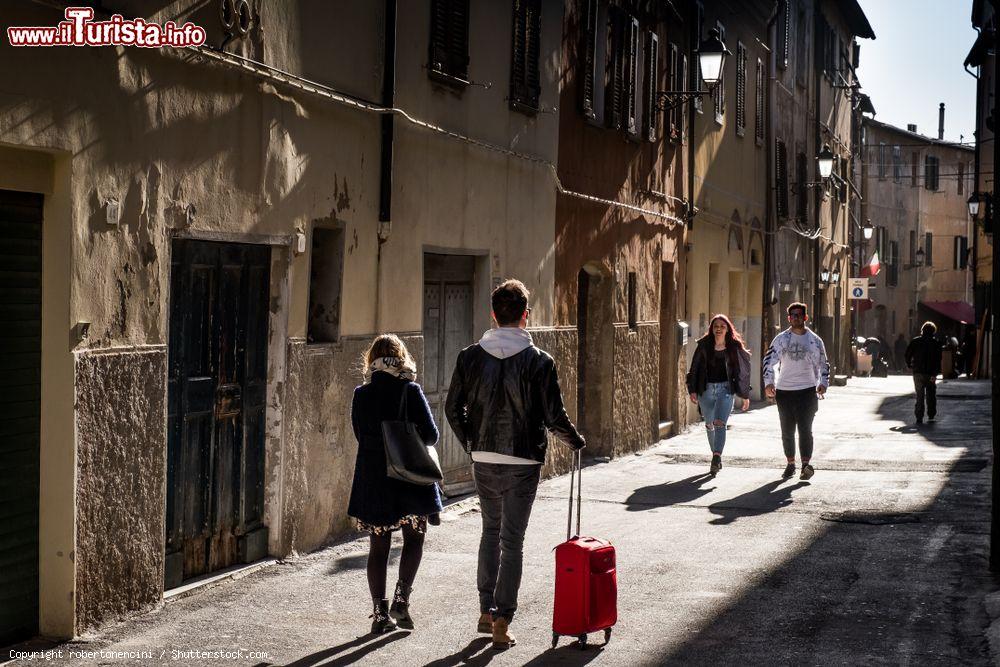 Immagine Gente a passeggio in un vicolo del centro storico di Piombino, Toscana - © robertonencini / Shutterstock.com