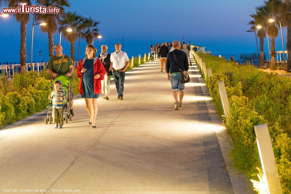 Immagine Gente a passeggio sul nuovo molo lungomare di Lido di Camaiore fotografato all'imbrunire, Lucca, Toscana - © pisaphotography / Shutterstock.com