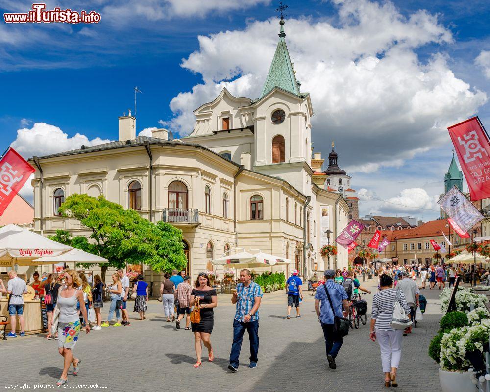 Immagine Gente a spasso nel centro di Lublino, Polonia, con la chiesa dello Spirito Santo in estate - © piotrbb / Shutterstock.com