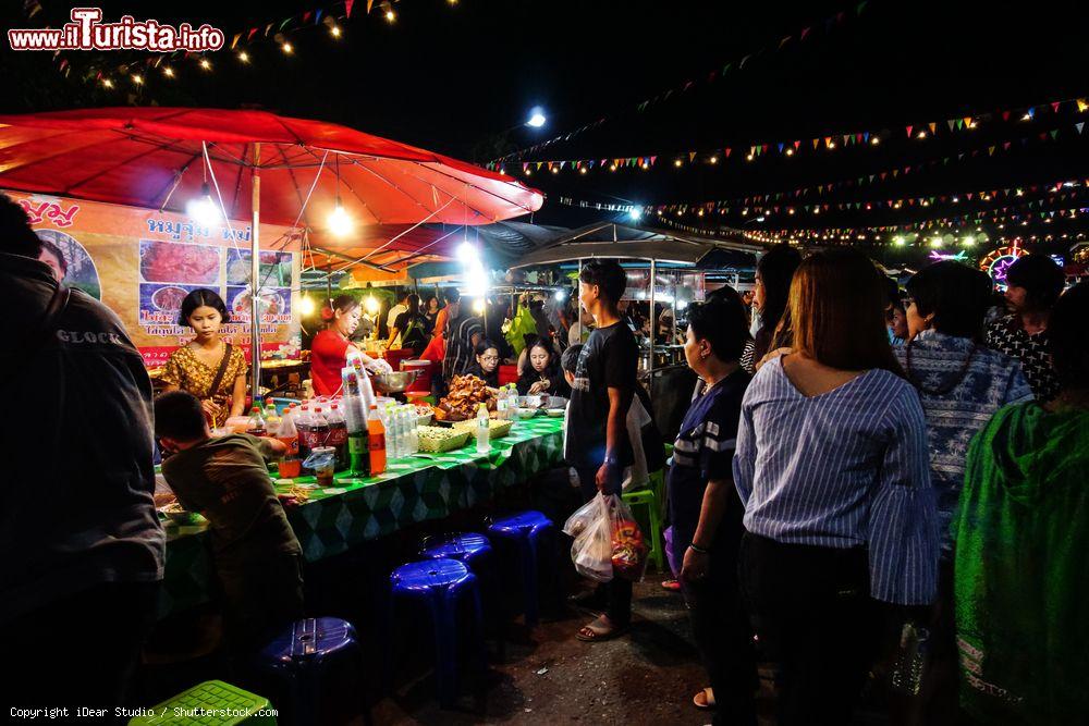 Immagine Gente al Sangkhlaburi street market a Kanchanaburi, Thailandia, by night. Questo pittoresco villaggio thailandese si trova nel cuore della regione di Kanchanaburi, fuori dai percorsi turistici. E' celebre per i suoi templi, los torico ponte in legno e i suoi mercati - © iDear Studio / Shutterstock.com