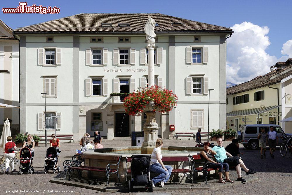 Immagine Gente di fronte al Municipio di Caldaro, Trentino Alto Adige. Nella piazza del mercato, proprio davanti al Rathaus, si trova la fontana di Maria - © Peter Probst / Shutterstock.com