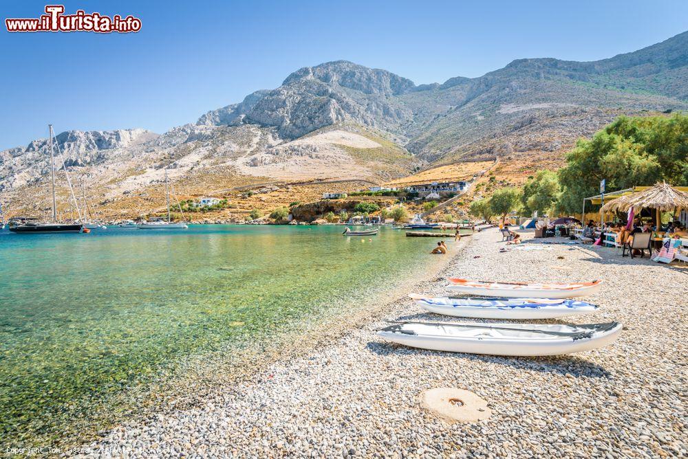 Immagine Gente in relax in una spiaggia di ciottoli sull'isola di Kalymnos, Grecia - © Tom Jastram / Shutterstock.com