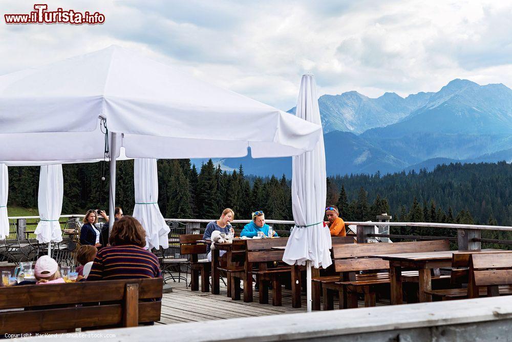 Immagine Gente in relax pranza in un caffé all'aperto con vista sui Tatra, Bukowina Tatrzanska (Polonia). Siamo nei pressi di Zakopane, località di villeggiatura alle pendici dei Tatra - © MarKord / Shutterstock.com