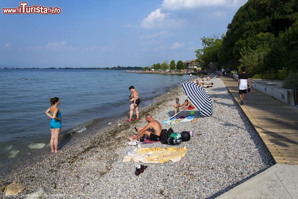 Immagine Gente in relax sulla spiaggia di Desenzano del Garda, provincia di Brescia, Lombardia. In prossimità del Lago di Garda ci sono quattro spiagge, tutte sassose: spiaggia Feltrinelli, di Rivoltella, di Desenzanino e d'Oro - © josefkubes / Shutterstock.com