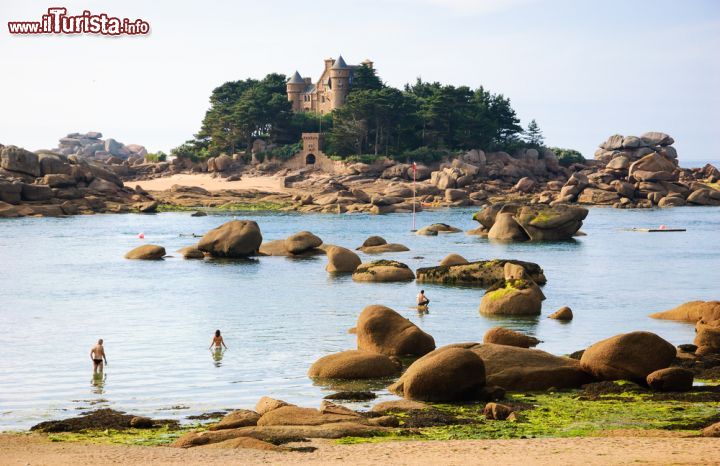 Immagine Gente in spiaggia a Ploumanac'h, Bretagna (Francia). Sullo sfondo, un castello della Costa di Grantio Rosa affacciata sulla Manica 
