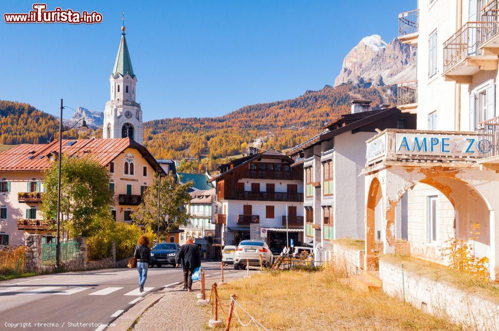 Immagine Gente in strada nel centro di Cortina d'Ampezzo, Veneto. Sullo sfondo, il campanile e le Alpi - © rbrechko / Shutterstock.com