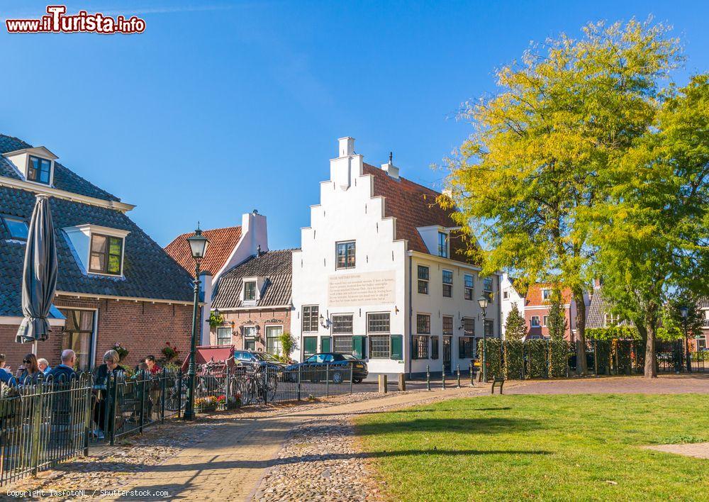 Immagine Gente in uno dei tanti locali del centro storico di Naarden, Paesi Bassi. Sullo sfondo, una casetta dal caratteristcio tetto a gradini - © TasfotoNL / Shutterstock.com