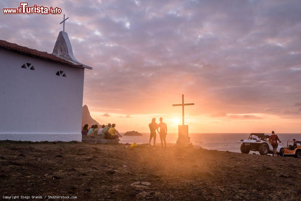 Immagine Gente osserva il tramonto alla Chapel of Sao Pedro dos Pescadores, isola di Fernando de Noronha, Pernambuco, Brasile - © Diego Grandi / Shutterstock.com