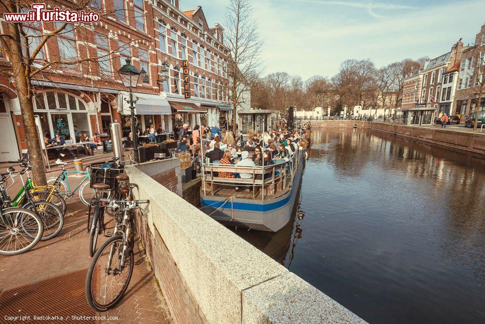 Immagine Gente su una barca trasformata in ristorante su un canale di Den Haag, Olanda, all'ora di pranzo - © Radiokafka / Shutterstock.com