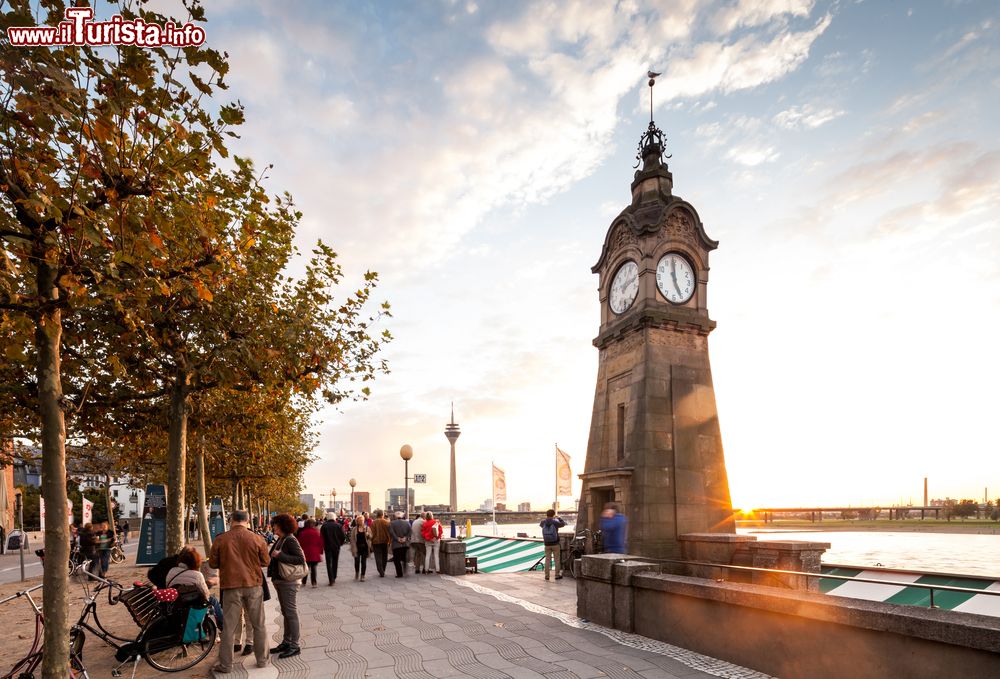 Immagine Gente sulla passeggiata lungo il fiume Reno al tramonto, Dusseldorf, Germania.