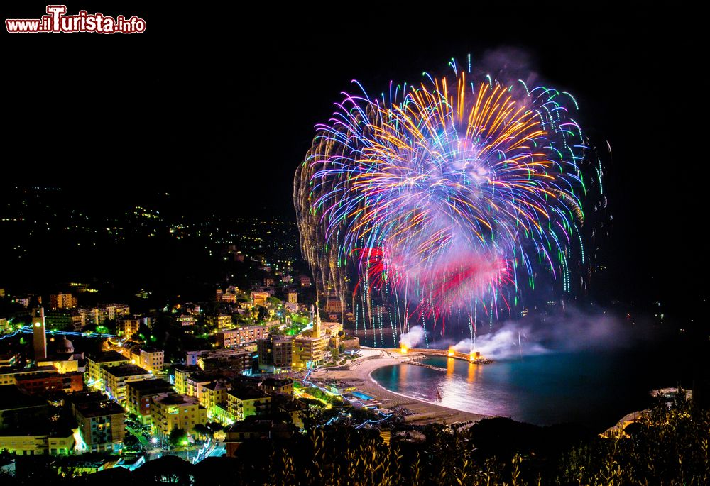 Immagine Giochi pirotecnici a Recco, Genova, Liguria. A rischiarare la notte di questa bella cittadina ligure ci sono colorati fuochi d'artificio che si riflettono sulle acque del mare.