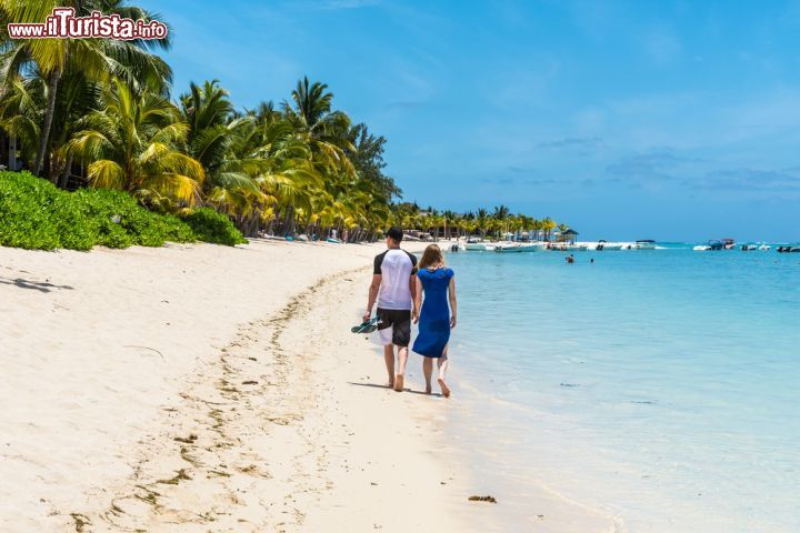 Immagine Una giovane coppia passeggia sulla spiaggia a Le Morne Brabant, Mont Choisy, Mauritius. Si tratta di una delle spiagge più belle dell'isola dove si trovano anche molti hotels e locali turistici - © byvalet / Shutterstock.com