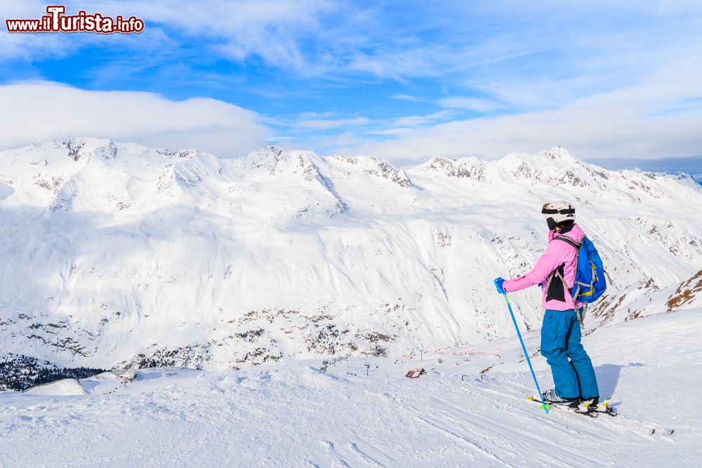 Immagine Una giovane sciatrice osserva il panorama innevato delle montagne a Obergurgl-Hochgurgl, Austria. Con i suoi 1930 metri di altezza, questa località è il paese più alto del territorio austriaco.