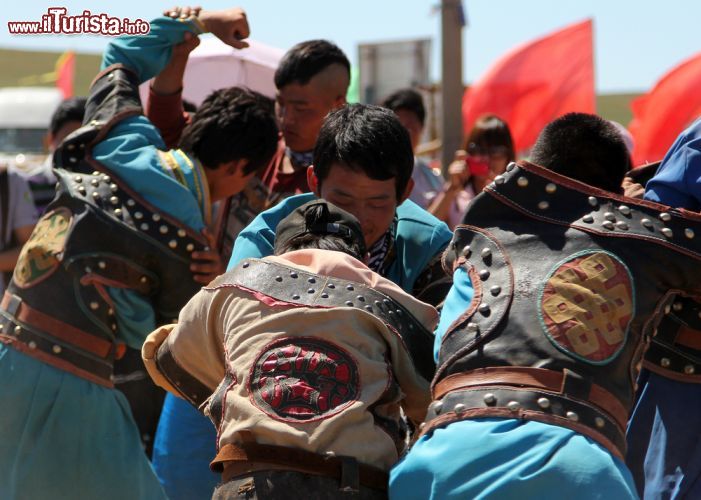 Immagine Giovani uomini partecipano a una tradizionale lotta nella steppa nei pressi di Hohhot, Cina. Questo tipo di combattimento fa parte della tradizione mongola e richiama l'attenzione di turisti provenienti da tutto il mondo - © Katoosha / Shutterstock.com
