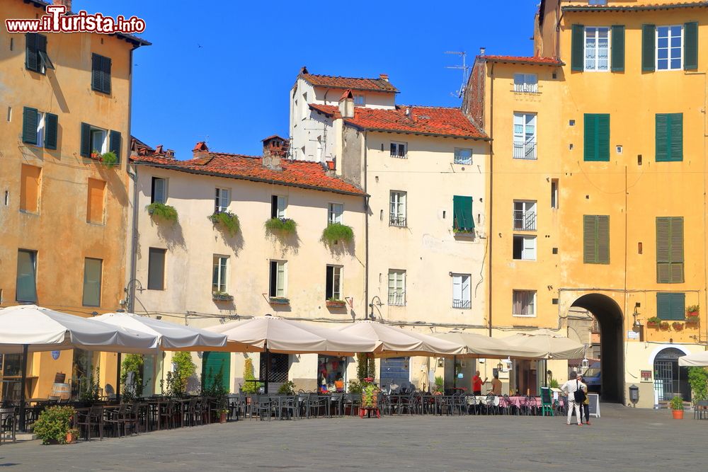 Immagine Gli antichi edifici di Piazza dell'Anfiteatro a Lucca, Toscana. L'accesso alla piazza è reso possibile attraverso 4 porte a volta di cui solo una però, quella più bassa, ricalca esattamente l'ingresso originario.