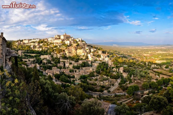 Immagine Panorama dall'alto sul villaggio di Gordes, Francia - Il borgo fortificato fotografato al tramonto si illumina di tonalità dorate © Martin M303 / Shutterstock.com