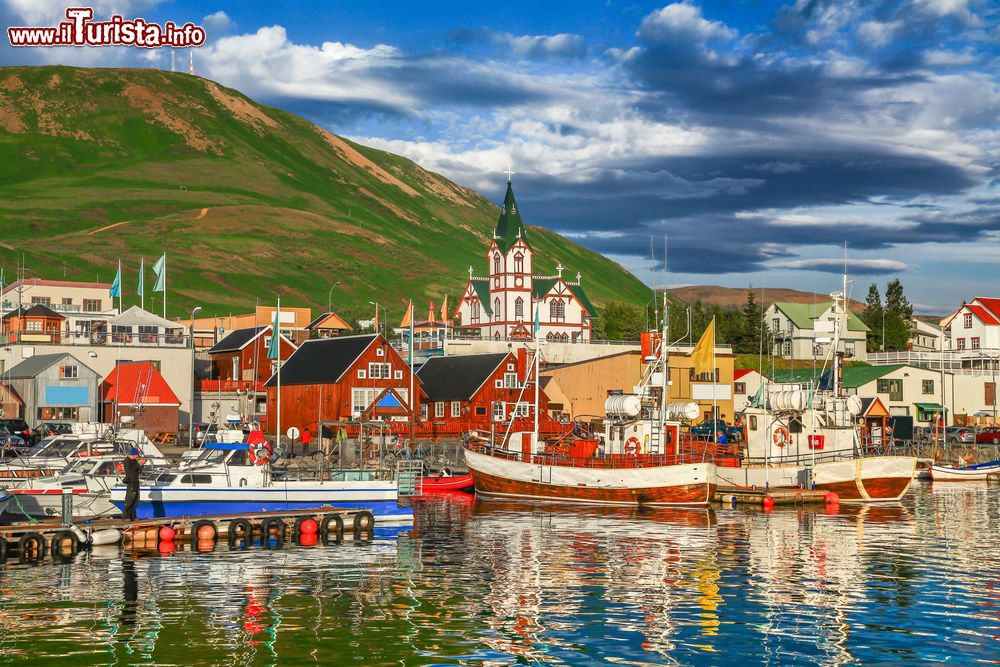 Immagine Il porticciolo di Husavik (Islanda) con le case dai tradizionali tetti a punta. Sullo sfondo la Húsavíkurkirkja, la chiesetta costruita nel 1907.