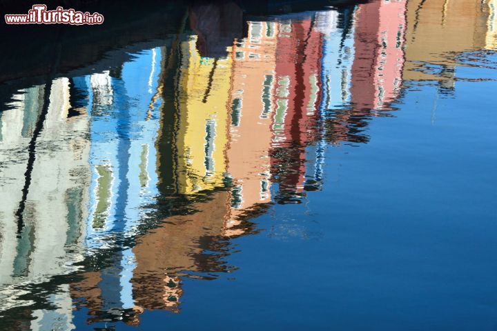 Immagine I colori vivaci di Burano riflessi nelle acque dei canali - uno dei principali simboli dell'isola di Burano, perla della Laguna di Venezia, è il colore. Ogni casa di Burano è infatti dipinta di un bel colore sgargiante e proprio per questo motivo, questa splendida località è stata inserita tra le dieci città più colorate del mondo. y - © Oleg Znamenskiy / Shutterstock.com