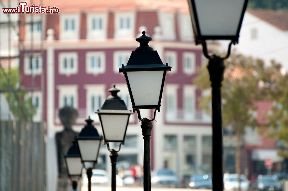Immagine I lampioni in fila lungo una strada della città di Alcobaca, Portogallo. Passeggiando a piedi alla scoperta di questa località se ne possono scoprire pittoreschi angoli architettonici.