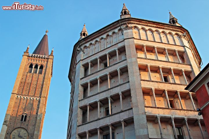 Immagine Gioco di luci e ombre su battistero e campanile di Piazza Duomo a Parma - il bellissimo Battistero di Parma, costruito tra il XII e il XIII secolo, svetta magnificamente nella Piazza del Duomo di Parma, insieme al campanile gotico della Cattedrale. Un complesso che è un grande tripudio d'arte in cui a giocare non sono solo luci e ombre, come in questa bella immagine, ma anche stili e colori: il romanico incontra il gotico, il rosa del marmo di Verona incontra le sfumature del rosso e del marrone nel mattone a vista, dando vita a panorami davvero suggestivi.  - © iryna1 / Shutterstock.com