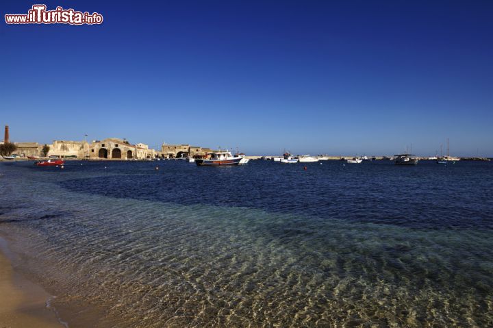 Immagine Il borgo marinaro di Marzamemi e la sua spiaggia, Sicilia - A piacere ai turisti, italiani ma anche stranieri che qui si recano in vacanza, sono i due porti naturali (Fossa e Balata) e la bella spiaggia che richiama anche gli abitanti della vicina Pachino  © Angelo Giampiccolo / Shutterstock.com