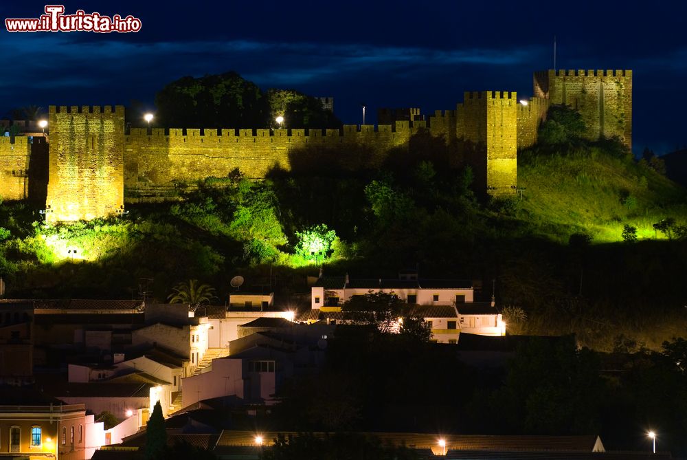 Immagine Il castello di Silves fotografato di notte, Portogallo. I resti del glorioso passato di questa città sono visibili in tutta Silves a partire dall'imponente castello di mattoni rossi che domina il profilo cittadino.