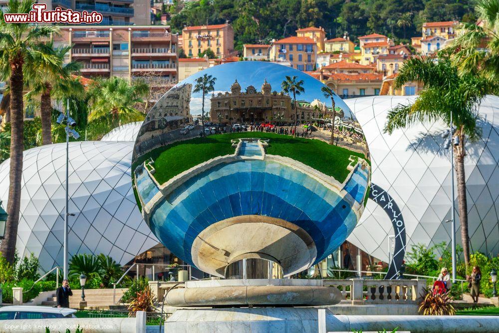 Immagine Il celebre casinò di Monte Carlo riflesso nella sfera a specchi della piazza, Principato di Monaco. E' stato costruito dall'architetto Charles Garnier in stile barocco: al suo interno il palazzo si presenta con affreschi e sculture oltre che con un atrio d'oro e di marmi - © kerenby / Shutterstock.com