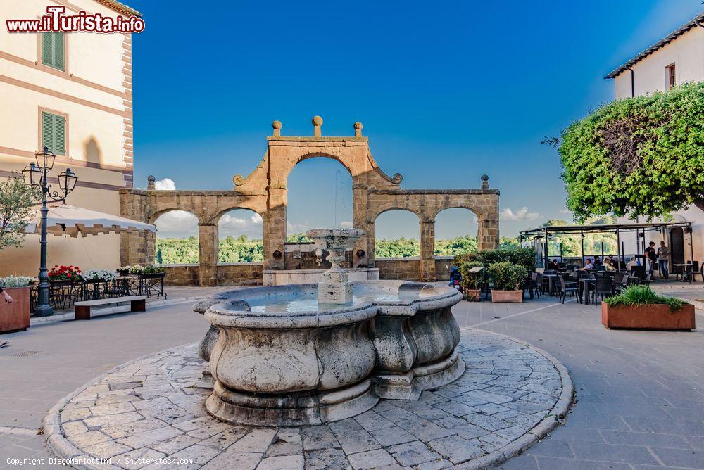 Immagine Il centro storico di Pitigliano con una fontana in pietra (Toscana) - © DiegoMariottini / Shutterstock.com